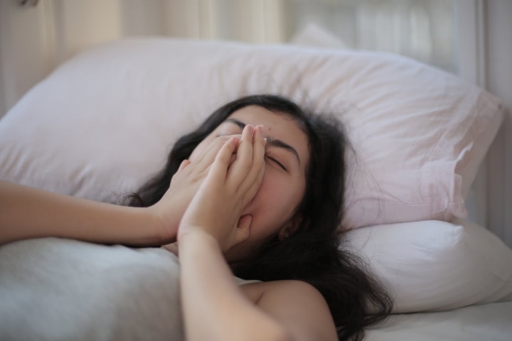 mujer bostezando en la cama